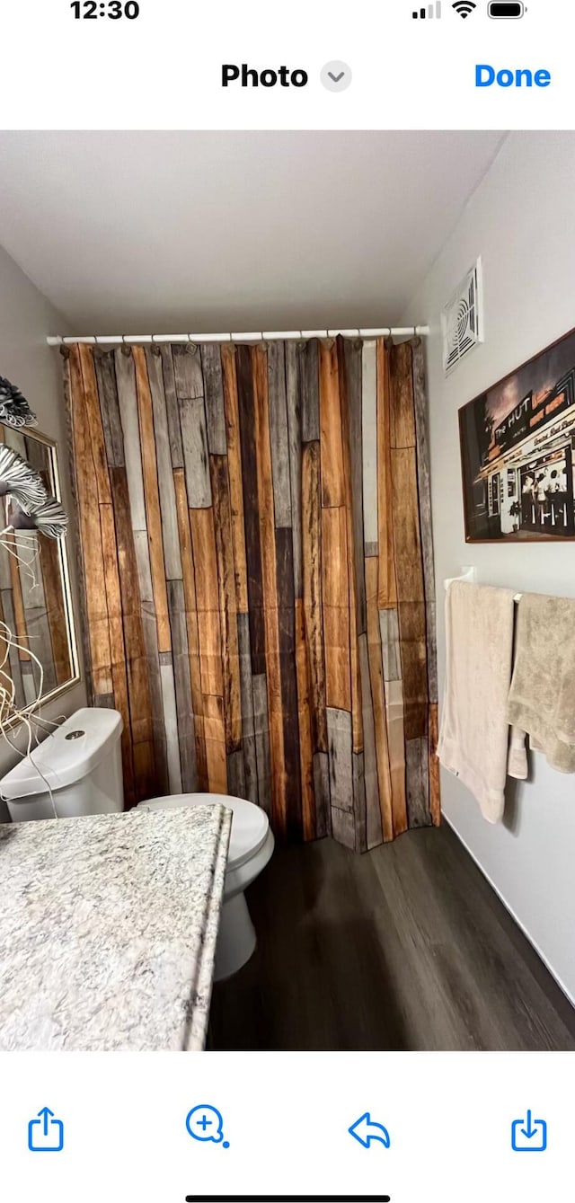 bathroom featuring hardwood / wood-style floors and toilet