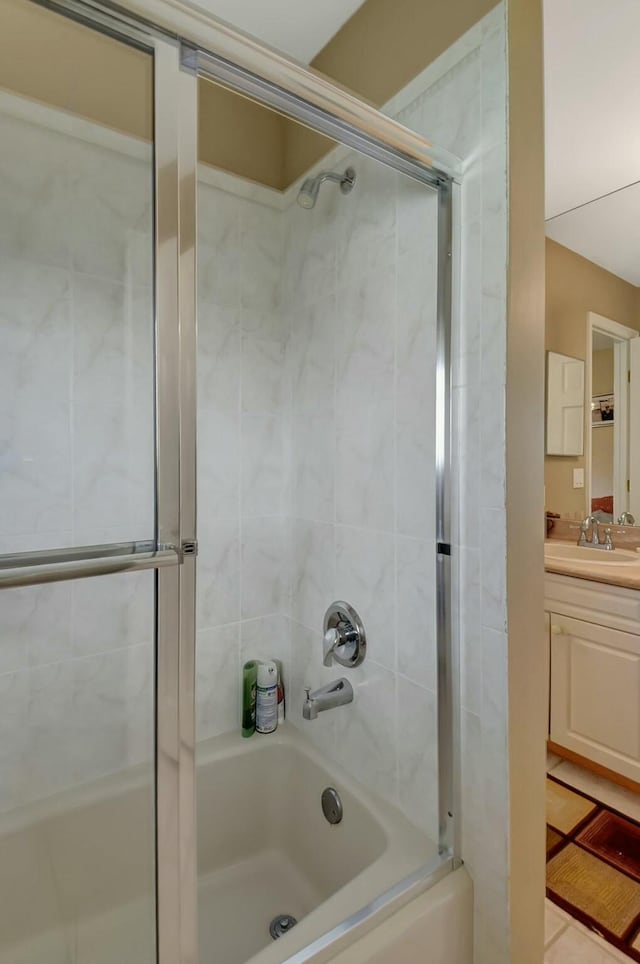 bathroom with tile patterned flooring, vanity, and bath / shower combo with glass door