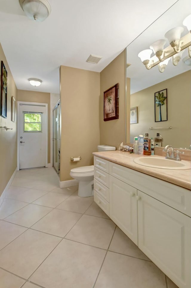 bathroom with tile patterned flooring, a chandelier, toilet, vanity, and a shower with shower door