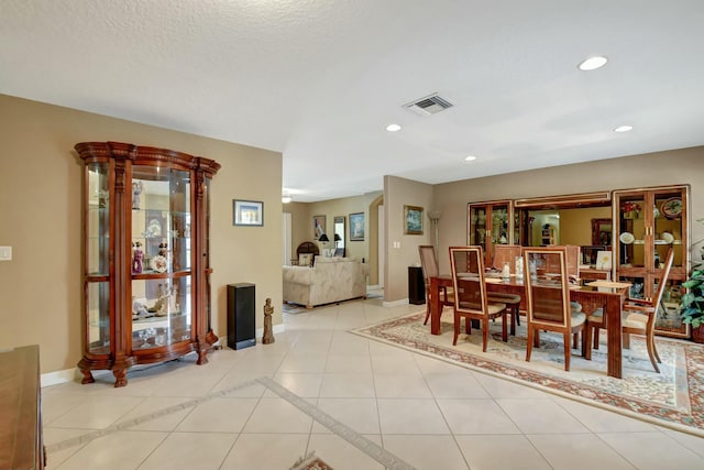 dining area with light tile patterned floors and a textured ceiling