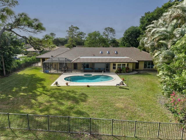 back of house featuring a yard, a fenced in pool, a patio, and glass enclosure