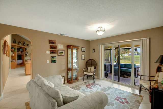 living room featuring light tile patterned floors and a textured ceiling