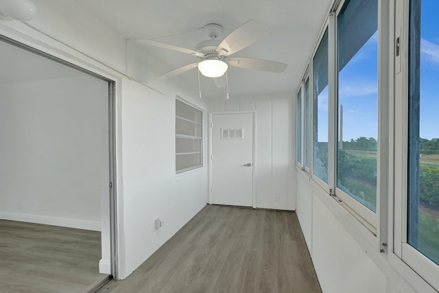 unfurnished sunroom with ceiling fan