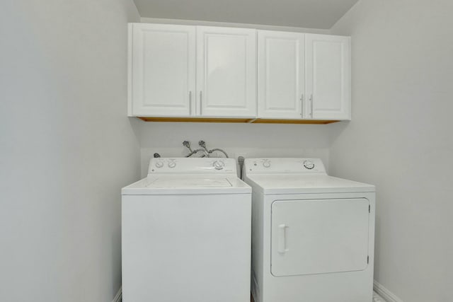 laundry area featuring cabinets and washer and clothes dryer