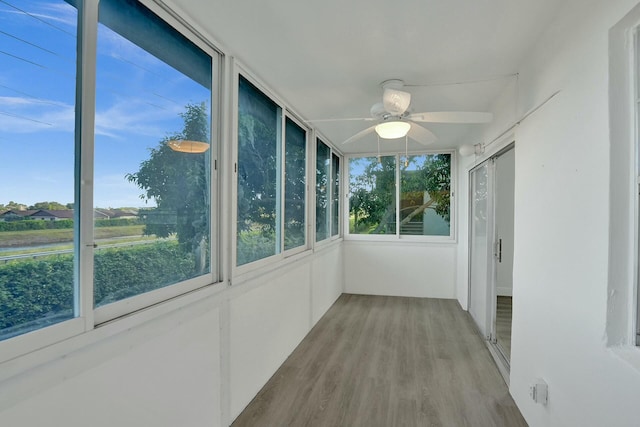 unfurnished sunroom featuring ceiling fan