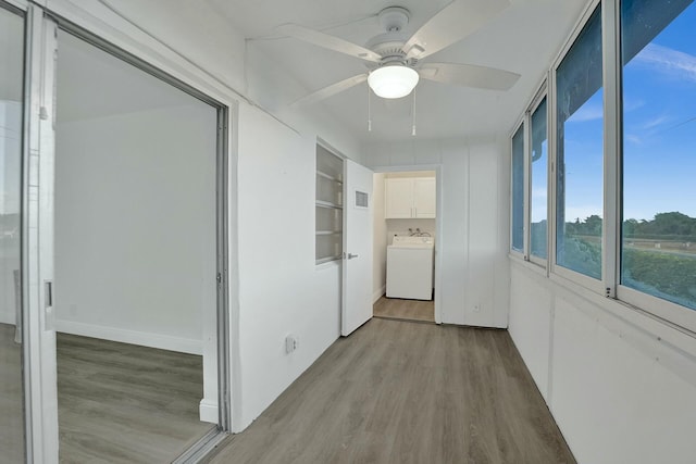 hallway with light hardwood / wood-style floors, washer / dryer, and built in features