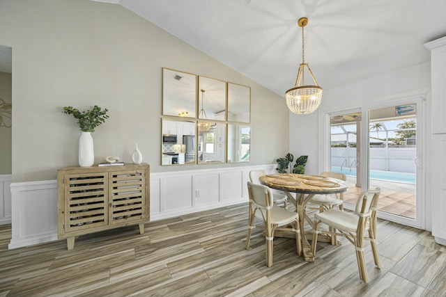 dining room with wood-type flooring, lofted ceiling, and a chandelier