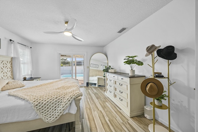 bedroom featuring access to exterior, ceiling fan, a textured ceiling, and light wood-type flooring