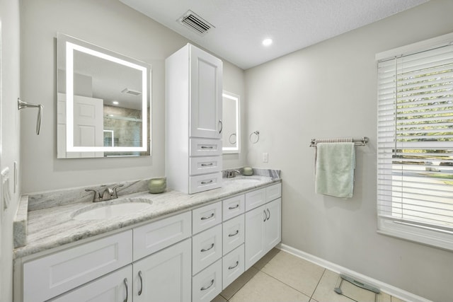 bathroom featuring tile patterned flooring, vanity, a textured ceiling, and an enclosed shower