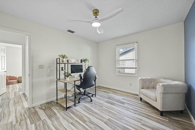 office featuring a textured ceiling, light hardwood / wood-style floors, and ceiling fan