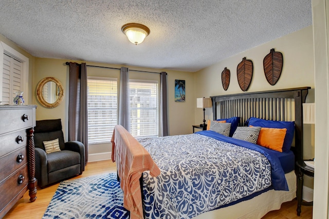 bedroom with light wood-type flooring and a textured ceiling