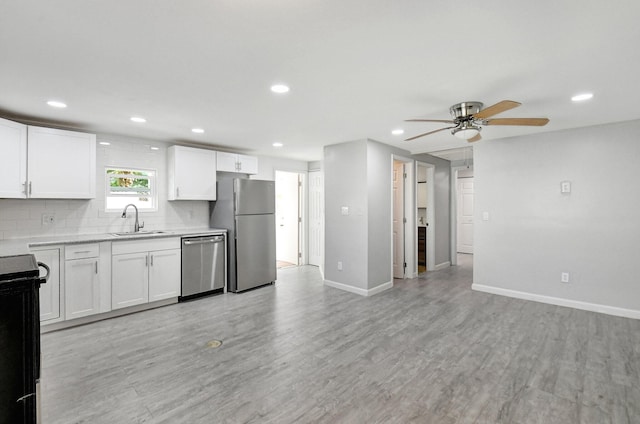 kitchen with backsplash, sink, white cabinetry, and stainless steel appliances