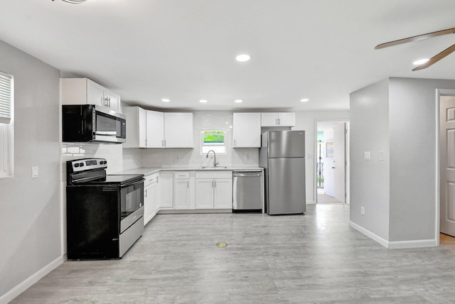 kitchen featuring sink, ceiling fan, appliances with stainless steel finishes, tasteful backsplash, and white cabinetry