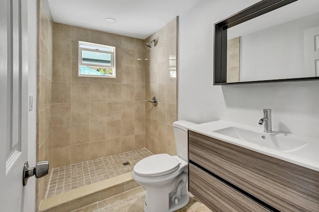 bathroom with tiled shower, vanity, toilet, and tile patterned flooring