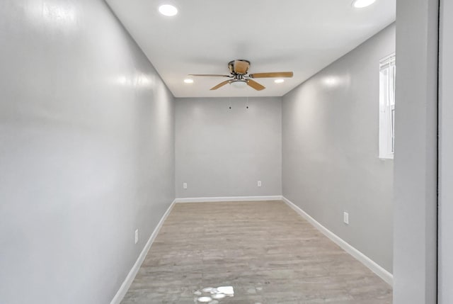 empty room with ceiling fan and light hardwood / wood-style flooring