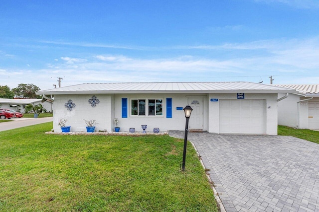 single story home featuring a garage and a front lawn