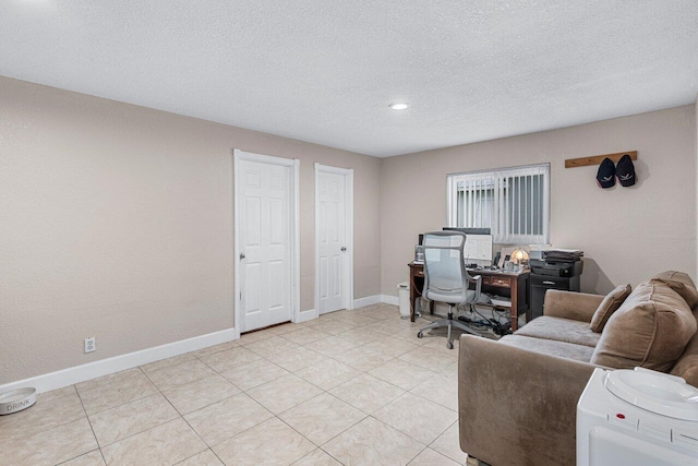 office area with light tile patterned flooring and a textured ceiling