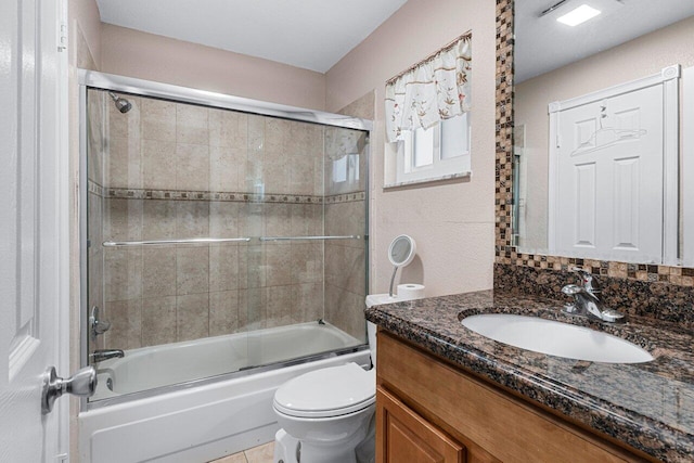 full bathroom with bath / shower combo with glass door, vanity, and toilet