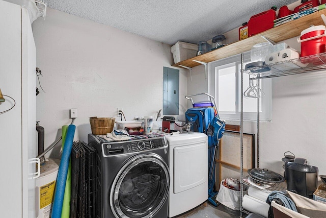 laundry area with washing machine and dryer, electric panel, and a textured ceiling