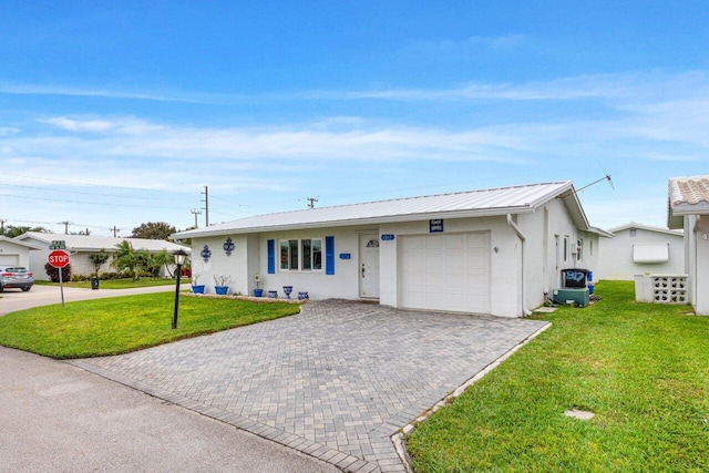 ranch-style house featuring a garage and a front lawn