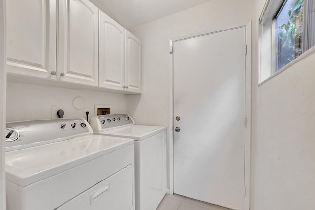 washroom featuring washer and dryer, light tile patterned flooring, and cabinets