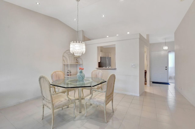 dining area with a notable chandelier, lofted ceiling, and light tile patterned flooring