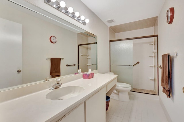 bathroom featuring tile patterned floors, vanity, toilet, and walk in shower