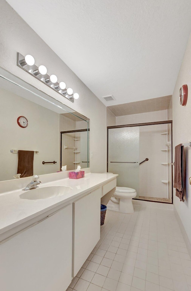 bathroom featuring tile patterned floors, toilet, vanity, and walk in shower