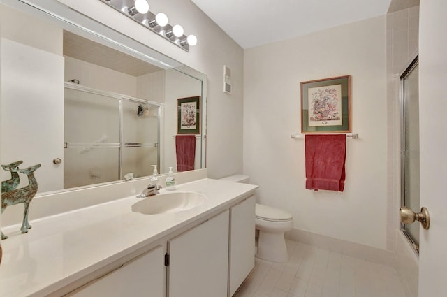 full bathroom featuring toilet, vanity, tile patterned floors, and bath / shower combo with glass door