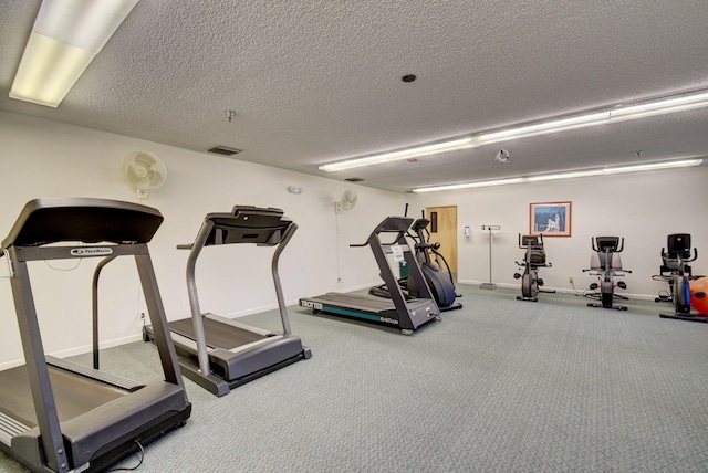 workout area featuring carpet flooring and a textured ceiling