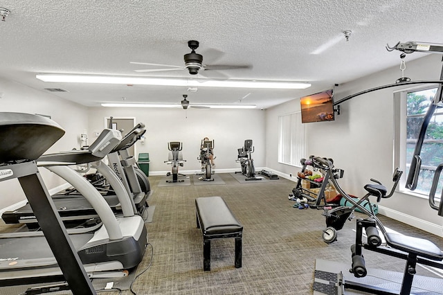 workout area featuring carpet flooring, ceiling fan, and a textured ceiling