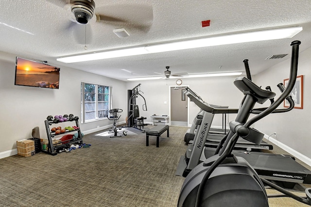 workout area featuring ceiling fan, carpet floors, and a textured ceiling