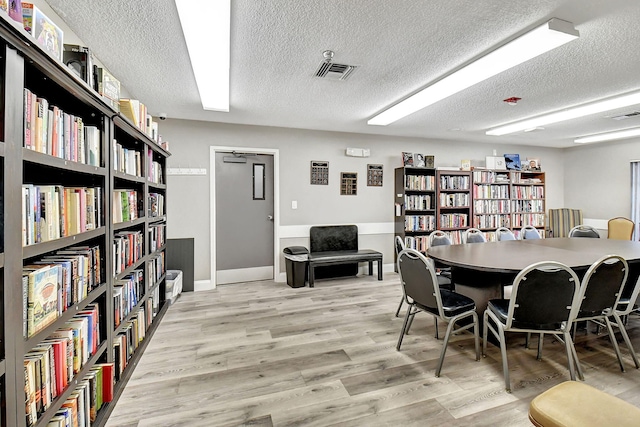 dining space featuring a textured ceiling and light hardwood / wood-style floors