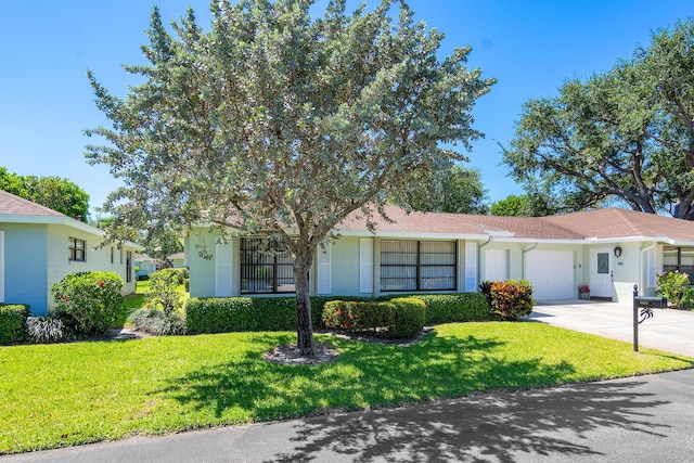 single story home featuring a garage and a front lawn