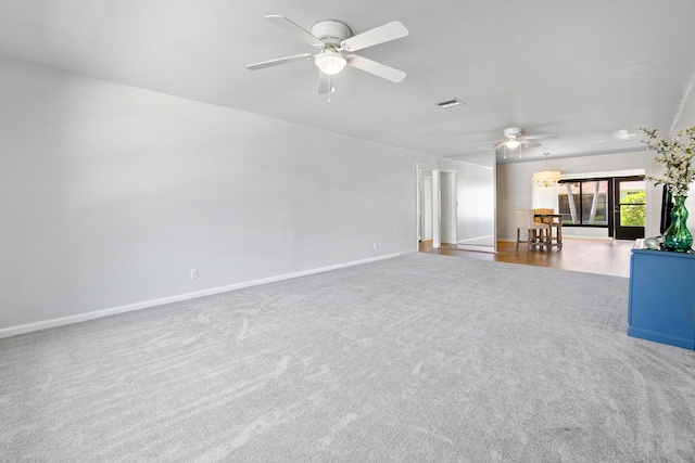 unfurnished living room featuring ceiling fan and carpet flooring