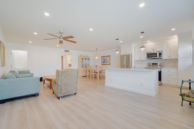 living room with light hardwood / wood-style flooring and ceiling fan