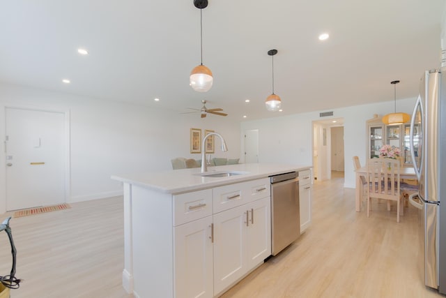 kitchen with visible vents, stainless steel appliances, light wood-style floors, and a sink