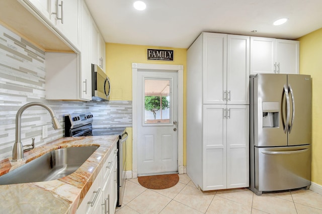 kitchen with white cabinets, backsplash, sink, and stainless steel appliances