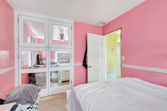 bedroom with light tile patterned flooring and a closet