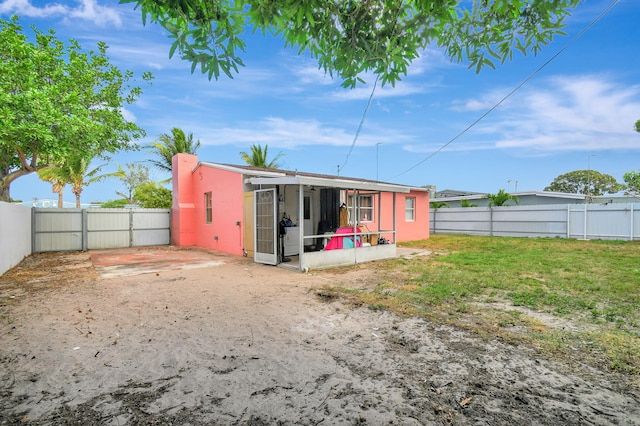 back of house featuring a patio and a lawn