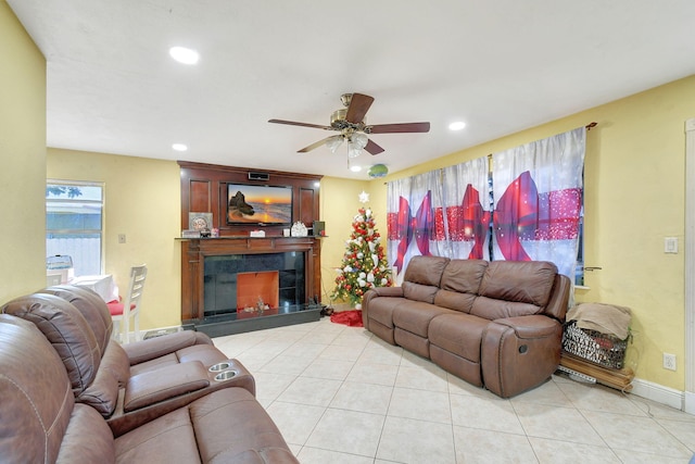 living room with ceiling fan, a high end fireplace, and light tile patterned flooring