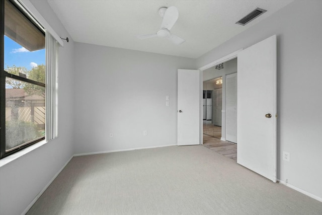 carpeted spare room with ceiling fan