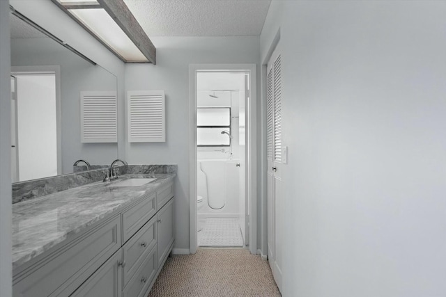 bathroom featuring a textured ceiling and vanity