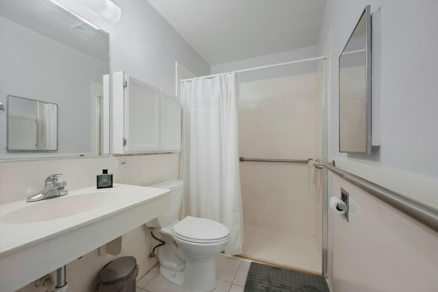 bathroom featuring toilet, tile patterned floors, curtained shower, and sink