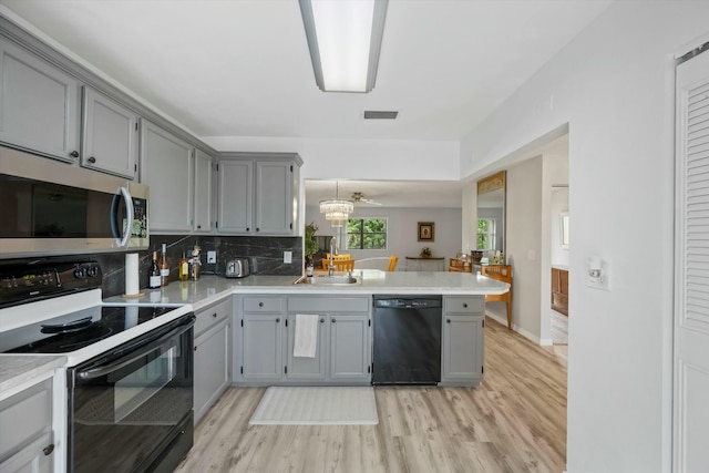 kitchen featuring kitchen peninsula, ceiling fan, black appliances, and light hardwood / wood-style floors