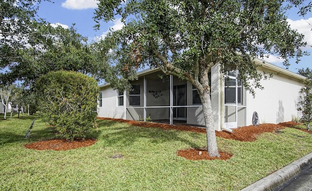 view of front of home featuring a front lawn and a sunroom