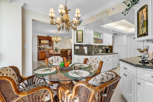 dining room with ornamental molding, sink, light tile patterned floors, and an inviting chandelier