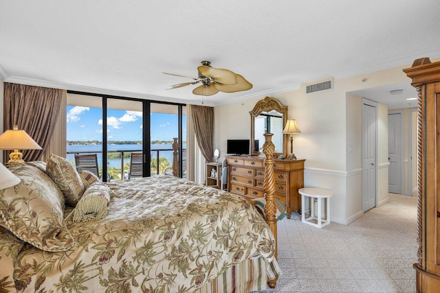 bedroom featuring access to exterior, ceiling fan, crown molding, and a wall of windows