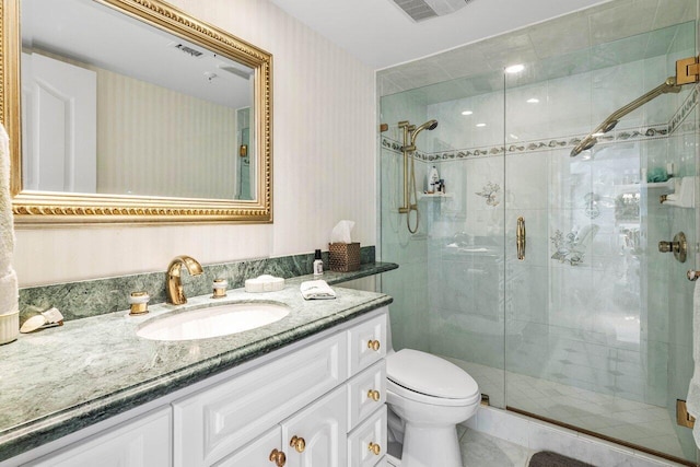 bathroom featuring tile patterned flooring, vanity, toilet, and a shower with door