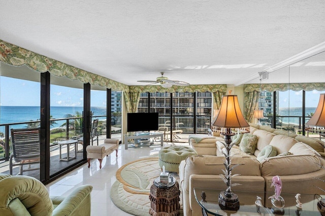 living room featuring ceiling fan, a healthy amount of sunlight, light tile patterned flooring, a textured ceiling, and a water view